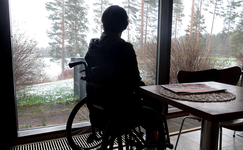 nainen pyörätuolissa katsoo ulos
